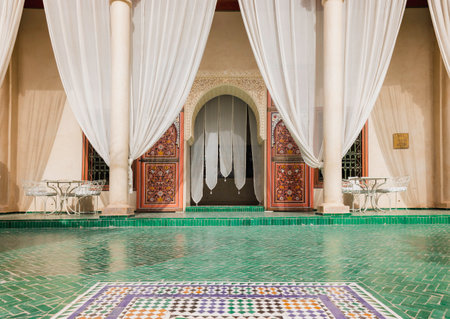 Elegant courtyard at Le Jardin Secret in Marrakech with green mosaic tiles, white curtains, and intricate Moroccan design, traditional architecture, and serene outdoor decorのeditorial素材