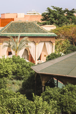Beautiful lush green botanical garden with tropical plants and palm trees and traditional Moroccan architecture at famous destination in Marrakech, Le Jardin Secret, Moroccoのeditorial素材