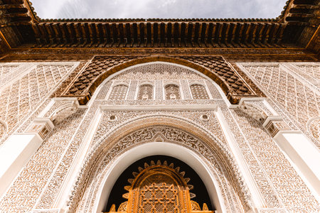 The decorative arch door facade in Ben youssef madrasa courtyard, ornate stucco plaster carving, example of traditional islamic architecture design in historic famous destination, Marrakech, Morocco,のeditorial素材
