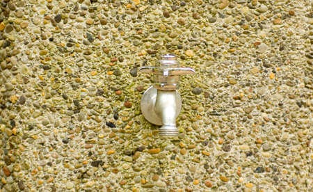 Silver water spout with knob on pebbles standの写真素材