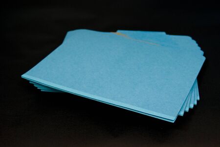 Blue file folders stacked and closed on black