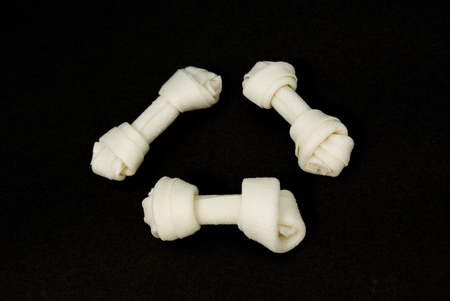 3 Dog bone rawhides on black backgroundの写真素材