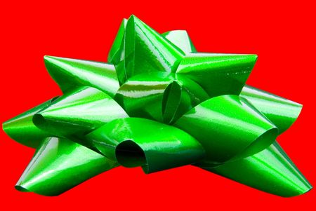 Green bow isolated on red backgroundの写真素材