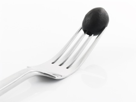 Olive on a fork with a white backgroundの写真素材