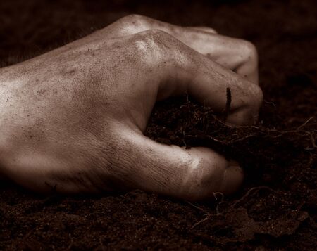 hand grabbing at dirt antique colorsの写真素材
