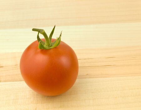 Single Ripe Tomato on a wooden backgroundの写真素材