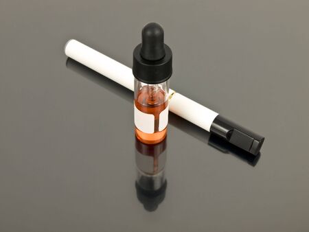 Electronic cigarette with refill e-juice on silver backgroundの写真素材