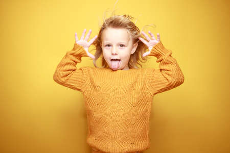 little girl smiling in front of a yellow backgroundの写真素材
