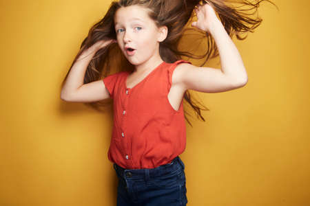 Little girl expressing joy and emotion through her body, her face while keeping the cute effect she wears with her fashion that is well on trend.の写真素材