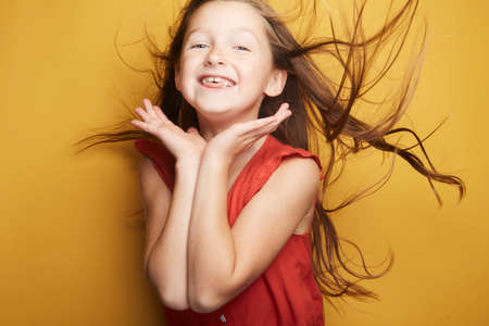 Little girl expressing joy and emotion through her body, her face while keeping the cute effect she wears with her fashion that is well on trend.の写真素材