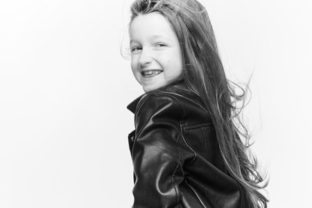 Little girl expressing joy and emotion through her body, her face while keeping the cute effect she wears with her fashion that is well on trend.の写真素材