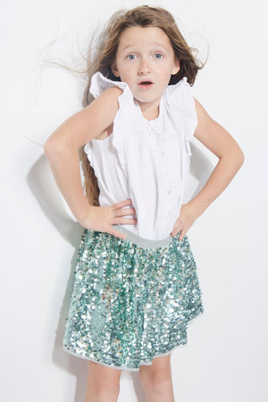 Little girl expressing joy and emotion through her body, her face while keeping the cute effect she wears with her fashion that is well on trend.の写真素材