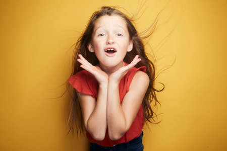 Little girl expressing joy and emotion through her body, her face while keeping the cute effect she wears with her fashion that is well on trend.の写真素材