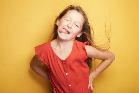 Little girl expressing joy and emotion through her body, her face while keeping the cute effect she wears with her fashion that is well on trend.の写真素材