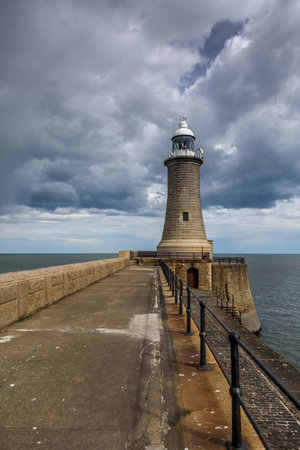The Lighthouse at the end of the North Pier in Tynemouth, England, on a cloudy dayの写真素材