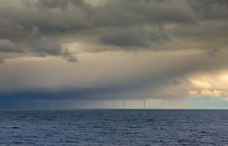 Several windmills off the coast of Tynemouth in the northeast of England, on a cloudy with a faint...