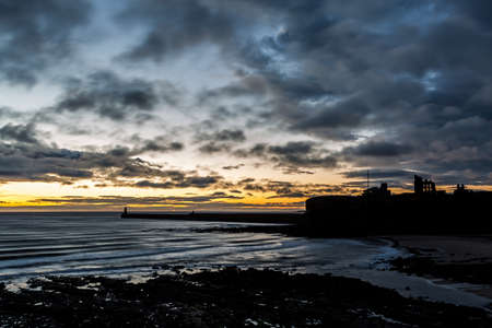 A beautiful sunrise at Tynemouth's King Edward's Bay with the sunlight catching the underside of the...