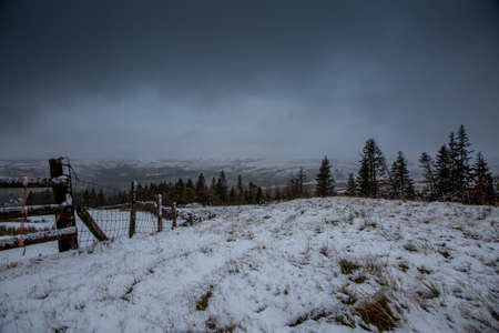 Snow covered fells of Cumbria as ominous looking clouds loom overheadの写真素材