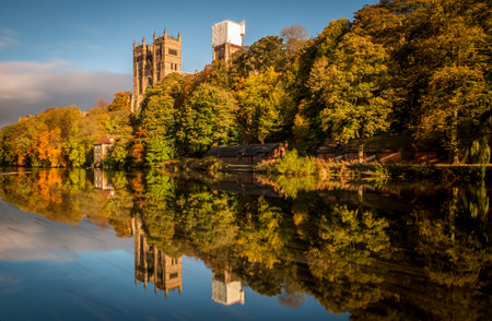 A long exposure of the beautiful Durham Cathedral and the Old Fulling Mill, with the autumn colors reflecting in the River Wearの写真素材