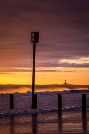 Sunrise to start the day at Blyth beach in Northumberland, with St Mary's Lighthouse in the distanceの写真素材