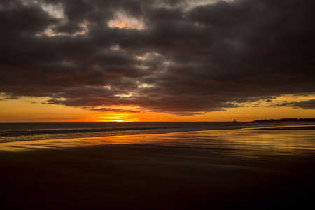 Sunrise to start the day at Blyth beach in Northumberland, with St Mary's Lighthouse in the distanceの写真素材