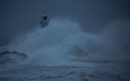The gale force winds from Storm Arwen cause giant waves to batter the lighthouse and north pier guarding the mouth of the Tyne in Tynemouth, Englandの写真素材