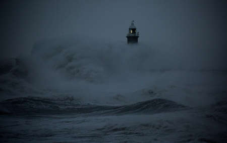 The gale force winds from Storm Arwen cause giant waves to batter the lighthouse and north pier guarding the mouth of the Tyne in Tynemouth, Englandの写真素材