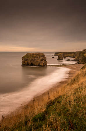 The view along Marsden Bay near Sunderland, of the cliffs and the Sandstone Sea stacks, as the tide comes inの写真素材
