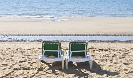 some green sun loungers looking out to seaの写真素材