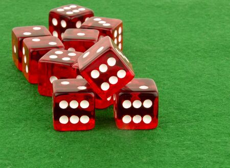 multiple red dice on green clothの写真素材