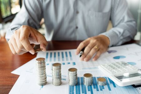 Business man hand putting coin stack for budget Saving money investment and financial accounting...