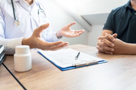 Doctor explaining and giving a consultation to a patient medical informations and diagnosis about the treatment for condition in hospital, medical ethics conceptの写真素材