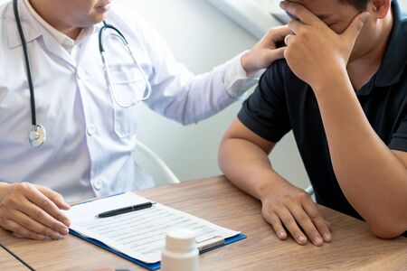 Doctor explaining and giving a consultation to a patient medical informations and diagnosis about the treatment for condition in hospital, medical ethics conceptの写真素材