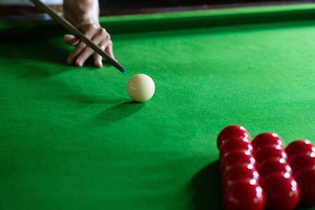 Game snooker billiards or opening frame player ready for the ball shot, athlete man kick cue on the green table in barの写真素材