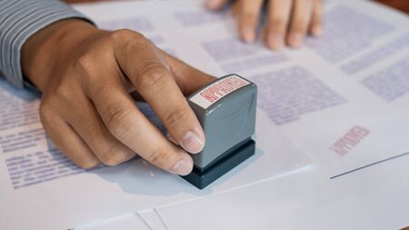 businessman Hand notary public hand ink appoval stamper Stamping seal On Approved Contract Form...