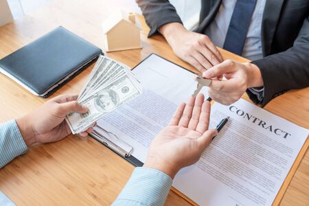 Businessman signs contract behind home architectural model Discussion with a real estate agent rental company staff  at the office property appraisal and valuation conceptの写真素材