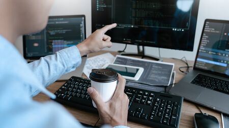 Programmer working On Computer In IT Office Typing Data Coding in software and checking code on...