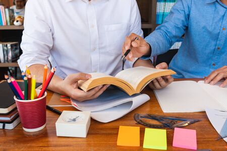 College tutor helps friend teaching and learning for a test or an exam catching up, education and...
