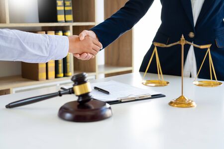 lawyers or attorneys discussing a contract agreement shaking hand after good deal contact, finishing up a meetingの写真素材