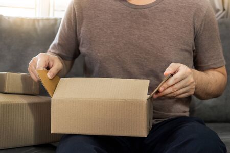 Startup small business entrepreneur SME, young asian man working with laptop computer and delivery packaging box, online market packing, SME e-commerce seller concept
の写真素材