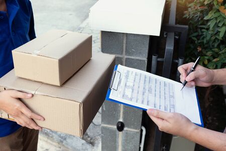 courier delivery man checking or holding cardboard parcel package to deliver to client for accepting...