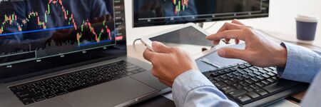Businessman broker Analyzing finance data graphs and reports on screen for investment purposes for...