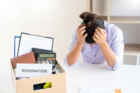 Stress of business woman packing brown cardboard box her belonging after resign and signing cancellation contract letter, Change of job unemployment or resignation conceptの写真素材