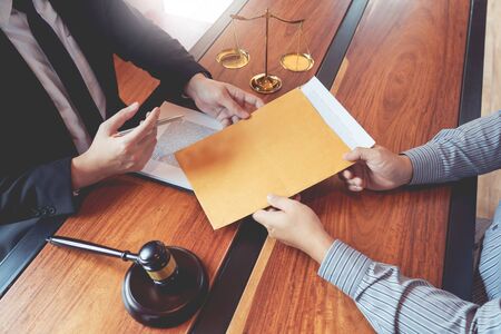 Lawyer working with client discussing contract papers with brass scale about legal legislation in courtroom, consulting to help their customerの写真素材