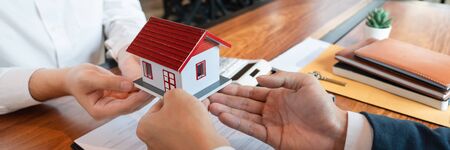buy or sell real estate concept, Sale representative offer house purchase contract to buy a house or apartment and give home key chain to customerの写真素材