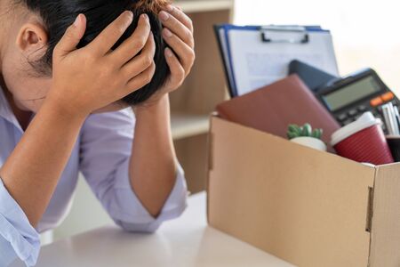 Businesswoman resigning from her job hold boxes and packing personal company for personal...
