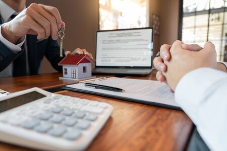 Real Estate broker or sale agent giving consultation to customer about buying house sign agreement document contract. Home loan conceptの写真素材