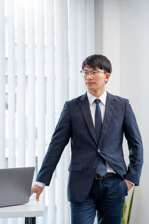 Stressed Young asian business man working late night alone in office late his eyes are gonna closing...