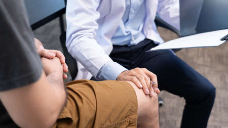 physiotherapist doctor rehabilitation consulting physiotherapy giving exercising knee treatment with...