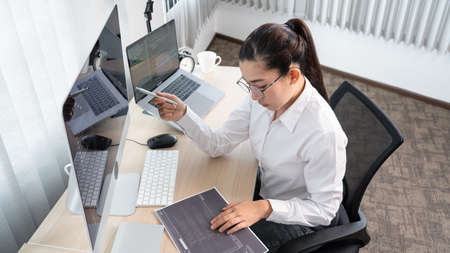 Young Asian woman Programmer Typing code working with computer at table, coding cyberspace and Web...